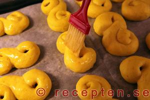 Pensla lussekatterna med uppvispat ägg. lussekatter penslas med uppvispat ägg