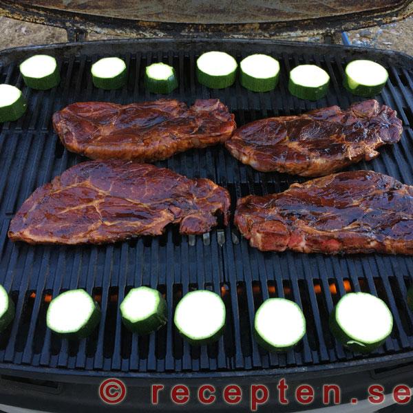 Grillning av karrékotletter och zucchini Grillar karrékotletter och zucchini