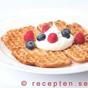 Goda frasiga våfflor serverade med grädde och bär Våfflor