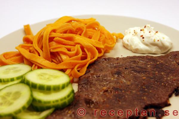 Lövbiff stekt och kryddad, serverad med pasta, kall sås och gurka. Stekt lövbiff med fettuchine, kall sås och gurka.