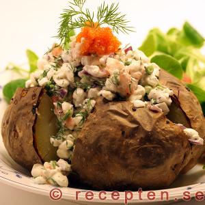 Bakad potatis med räkor och kesoröra garnerad med röd stenbitsrom. bakad potatis med räkor och kesoröra
