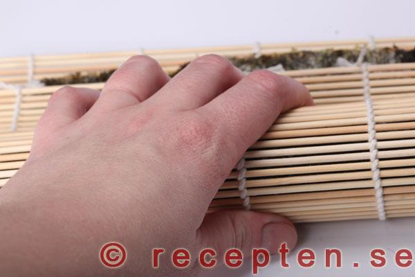 tryck ihop sushirullen med bambumattan
