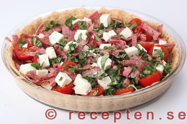 salami, fetaost, tomater och basilika fördelat i pajskalet